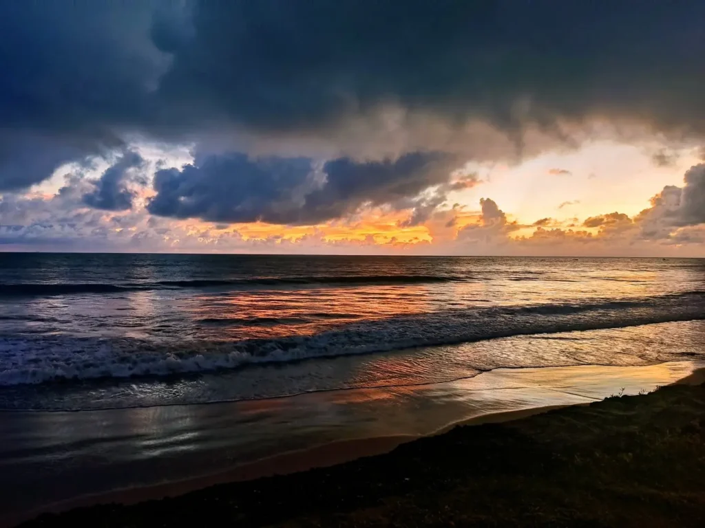 João Pessoa, a cidade mais oriental das Américas. Nascer do sol na orla da praia do Bessa, lindo reflexo do sol sobrea o mar e a areia molhada